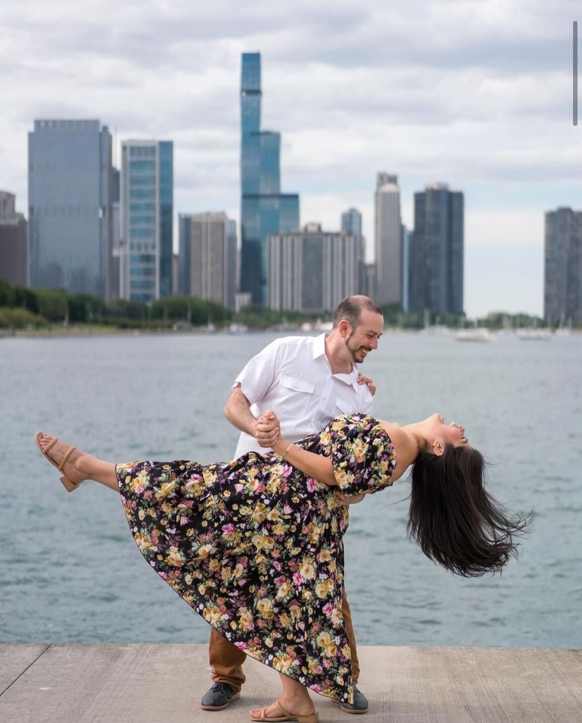 Chicago couple posing for engagement photos in front of Chicago skyline