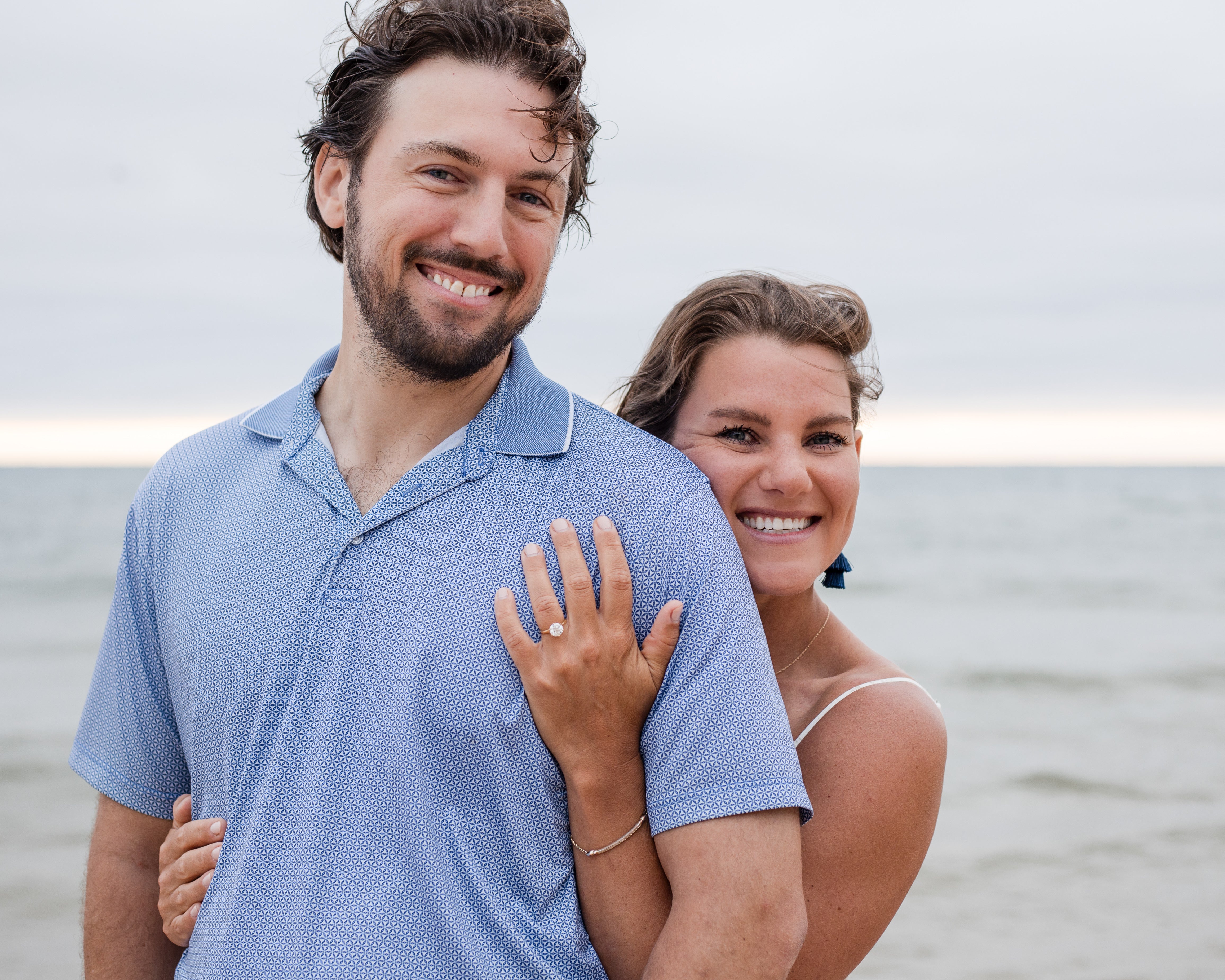 couple posing for proposal pictures on the beach
