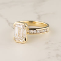 Half-bezel engagement ring setting with channel baguette side stones