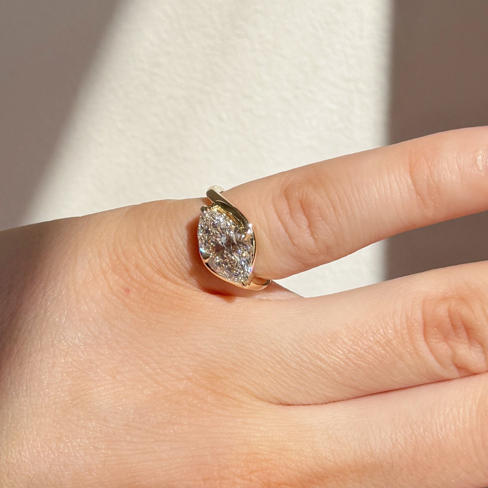 On hand shot of a curvy bypass engagement ring