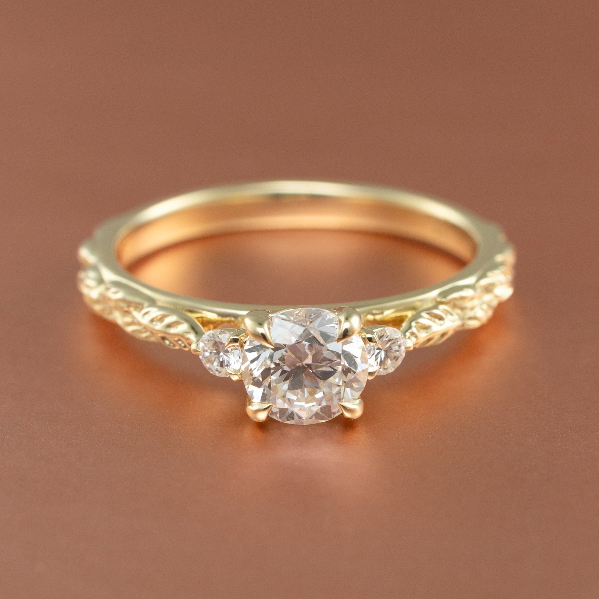 front view angle of a three stone engagement ring setting with leaf detailing