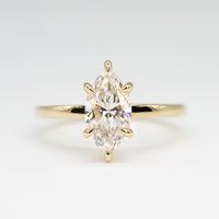 hitched yellow gold signature solitaire engagement ring with marquise center and talon prongs