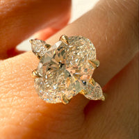 hitched yellow gold signature three-stone engagement ring with oval center and pear side stones