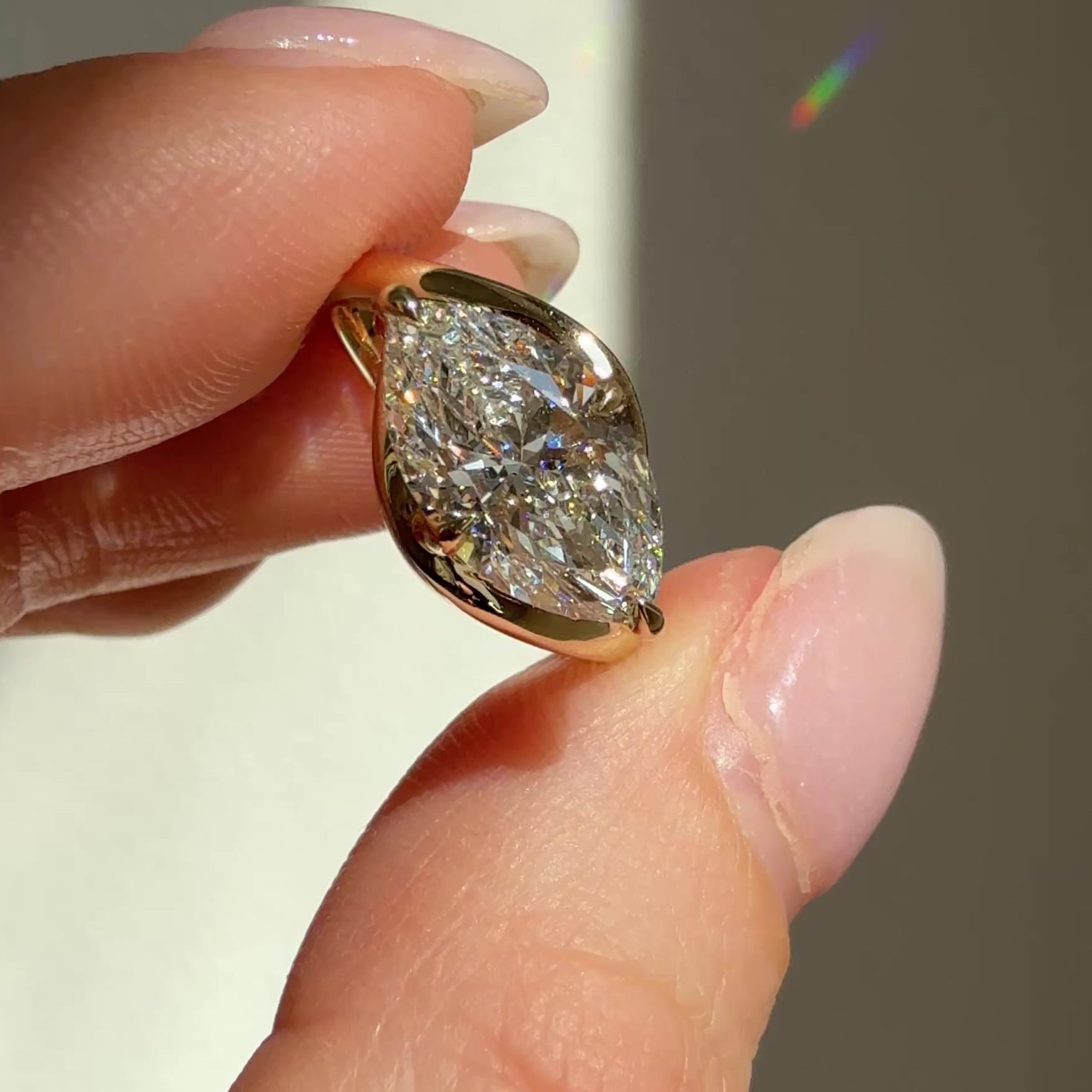 Video of a curvy bypass engagement ring with an east west set marquise center diamond