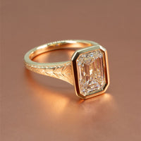 Tapered bezel-set engagement ring with hand-engraved band detailing