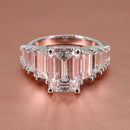 platinum tapering straight baguette engagement ring with emerald diamond center on a rose gold background