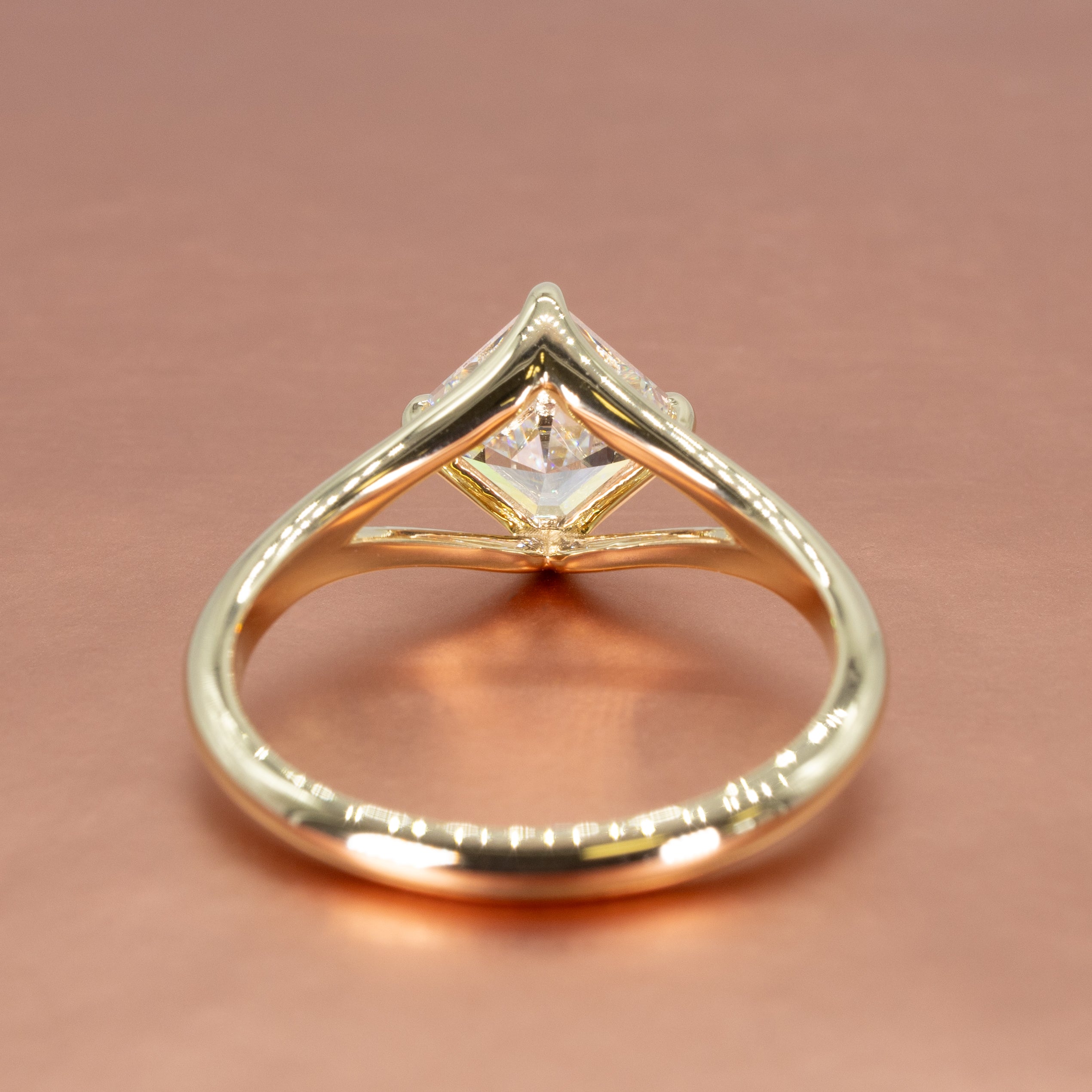 Basket view of a yellow gold split shank engagement ring with a kite set asscher cut diamond