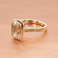 hitched yellow gold bezel set engagement ring with rose filigree detail and old mine diamond center