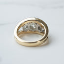 The basket view of a dual-tone three-stone round diamond engagement ring