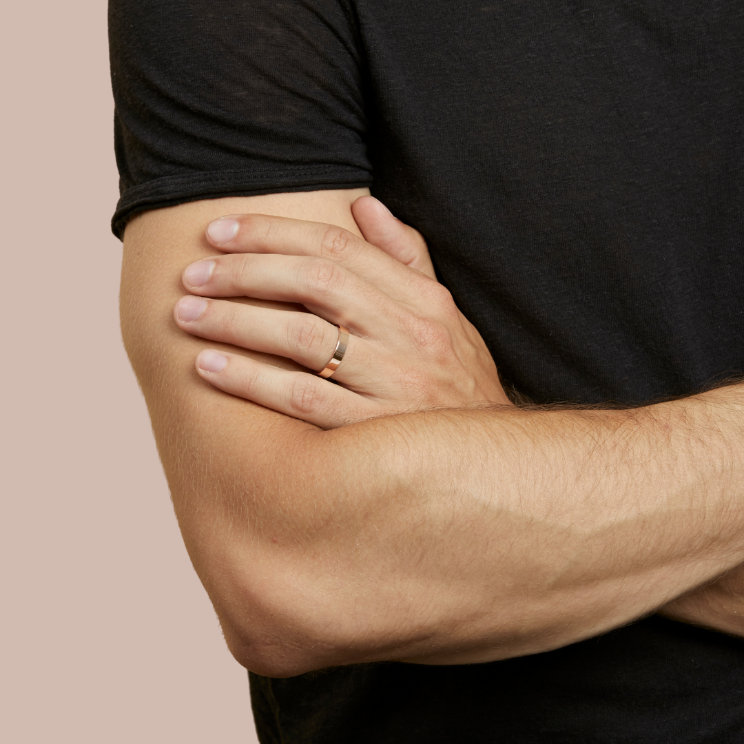 hitched men's rose gold flat wedding band in a 4mm width on model